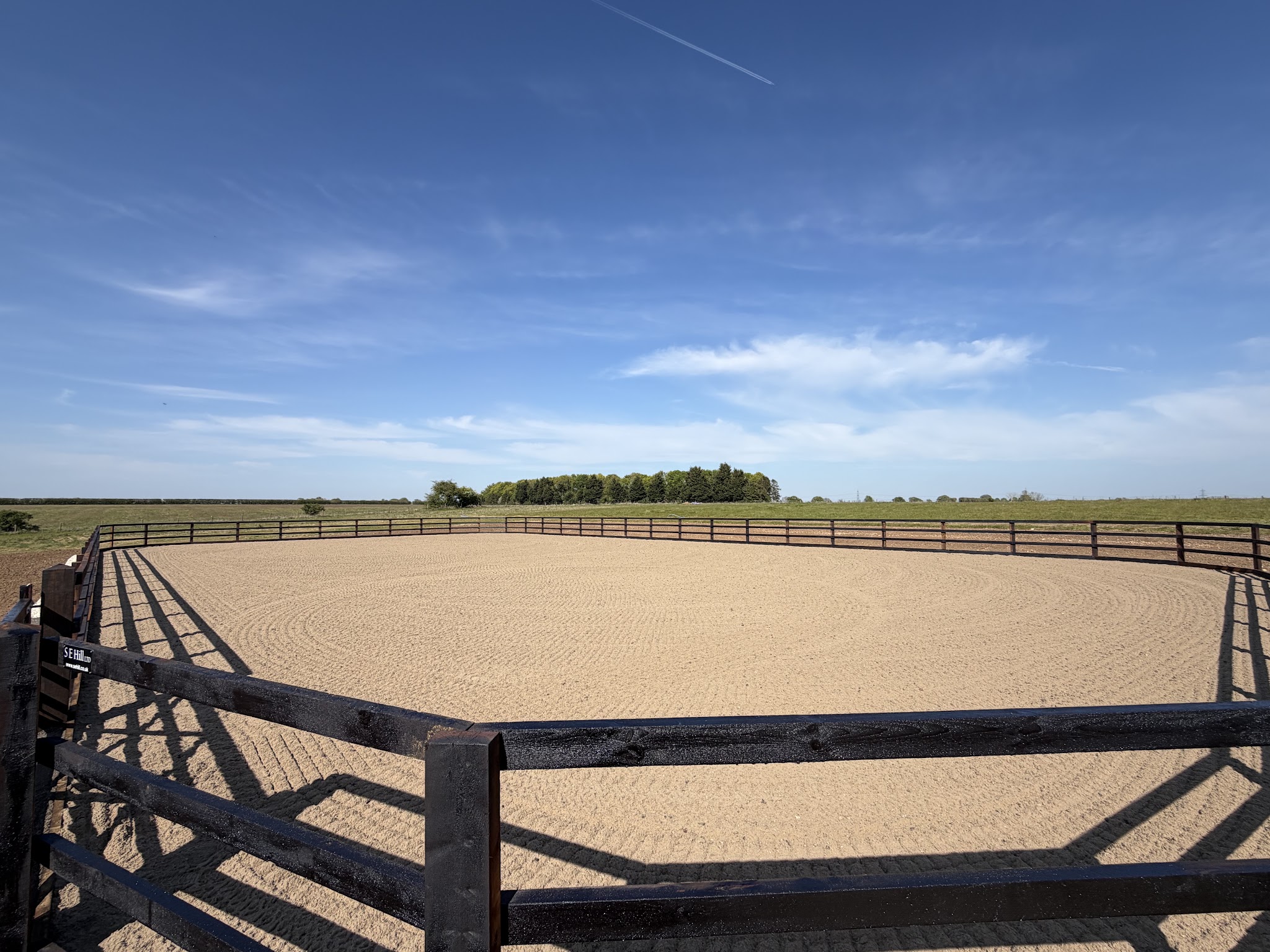 Raked arena surface with rounded corners and dark fencing
