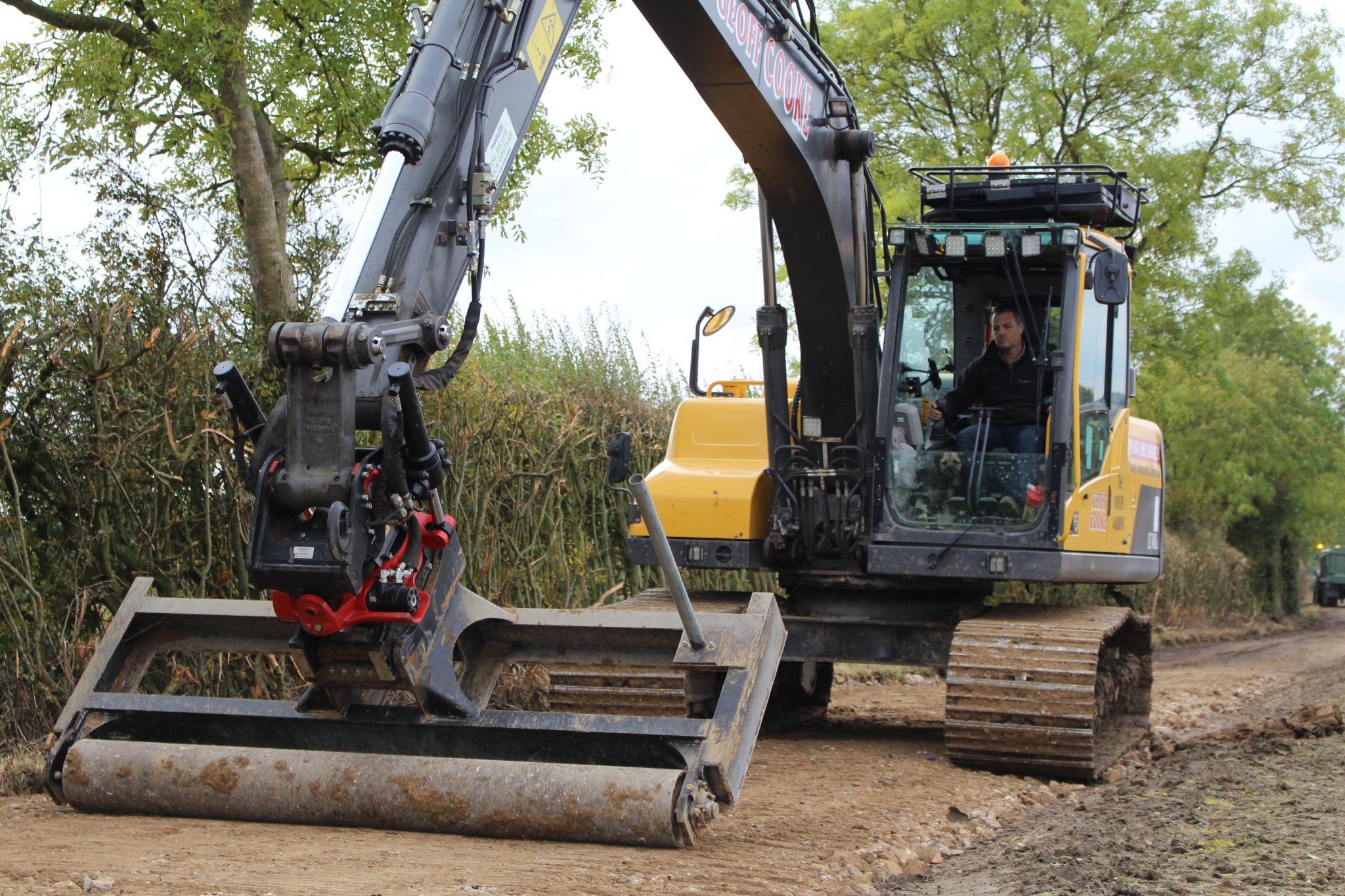 Volvo excavator with a roller attachment, operator in the cab