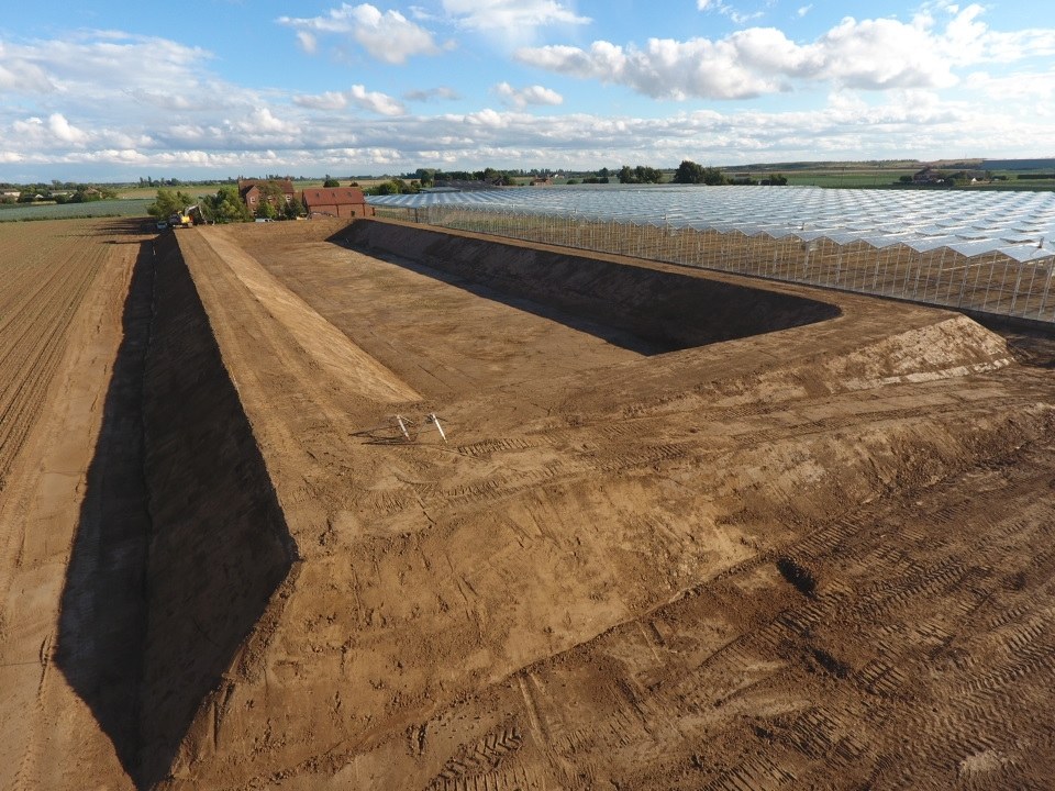 Reservoir banks shaped across a large field